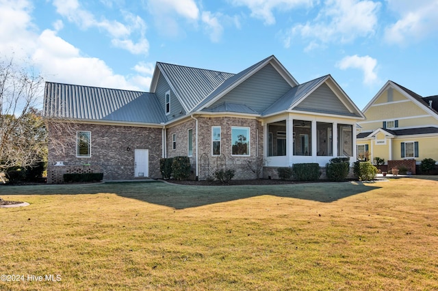 view of front of house with a front yard and a sunroom