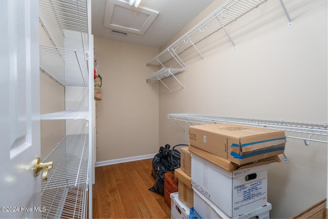 walk in closet with hardwood / wood-style flooring