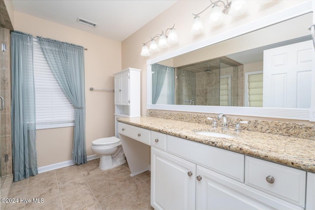 bathroom with tile patterned flooring, vanity, toilet, and a shower with shower door