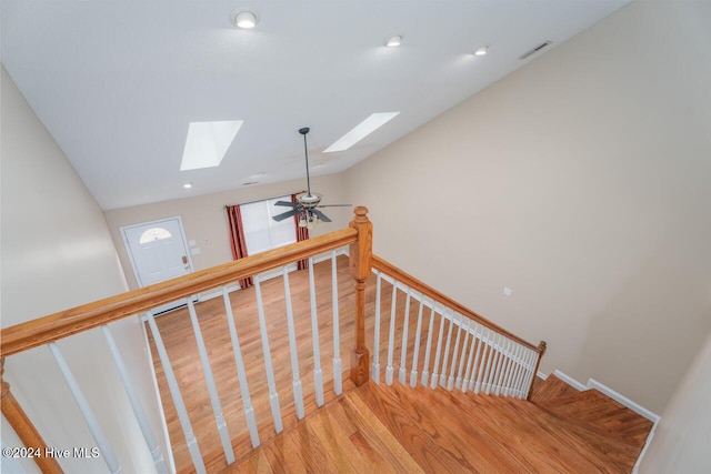 staircase featuring hardwood / wood-style flooring, a skylight, and ceiling fan