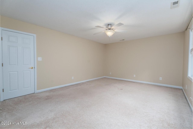 carpeted spare room featuring ceiling fan