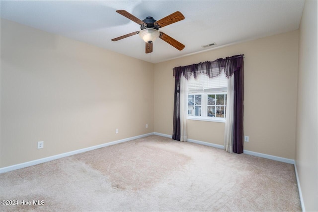 carpeted spare room featuring ceiling fan