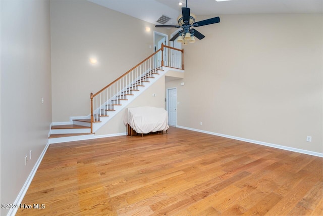 unfurnished living room featuring ceiling fan, high vaulted ceiling, and light wood-type flooring