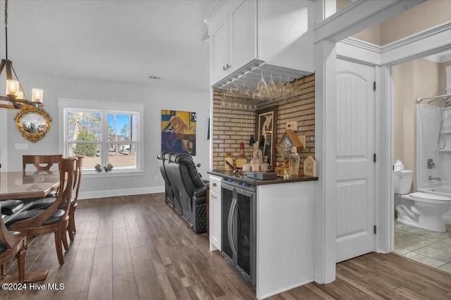 kitchen featuring decorative light fixtures, white cabinetry, wine cooler, and dark wood-type flooring