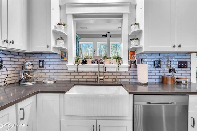 kitchen with stainless steel dishwasher, white cabinets, and tasteful backsplash