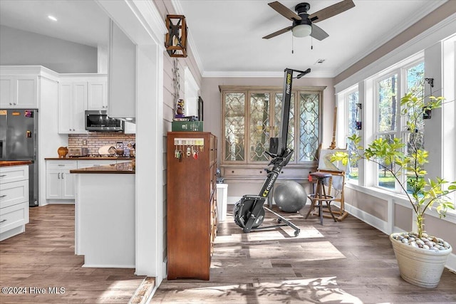 exercise area featuring hardwood / wood-style floors, ceiling fan, and a wealth of natural light