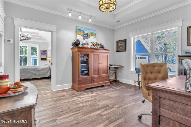 home office with light wood-type flooring, a raised ceiling, crown molding, and an inviting chandelier