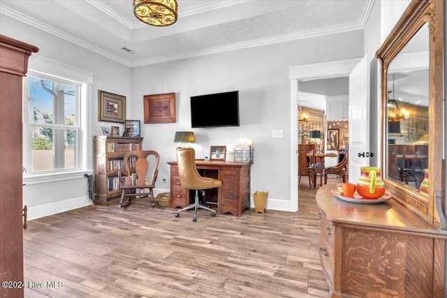 home office featuring hardwood / wood-style floors, ornamental molding, and a raised ceiling