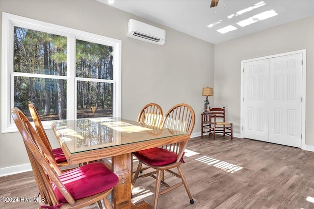 dining room featuring ceiling fan, hardwood / wood-style floors, and an AC wall unit