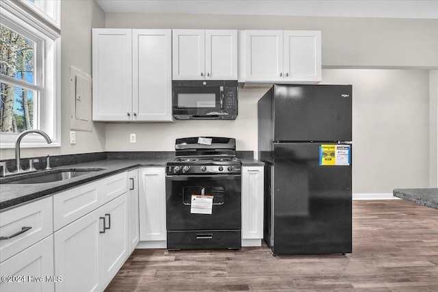 kitchen with black appliances, white cabinets, and sink