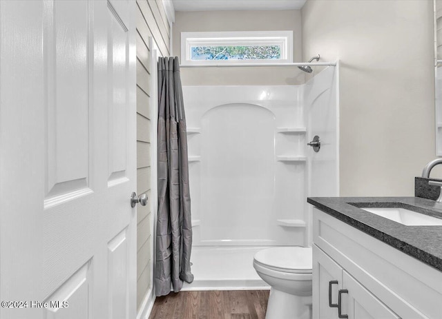 bathroom with toilet, curtained shower, wood-type flooring, and vanity