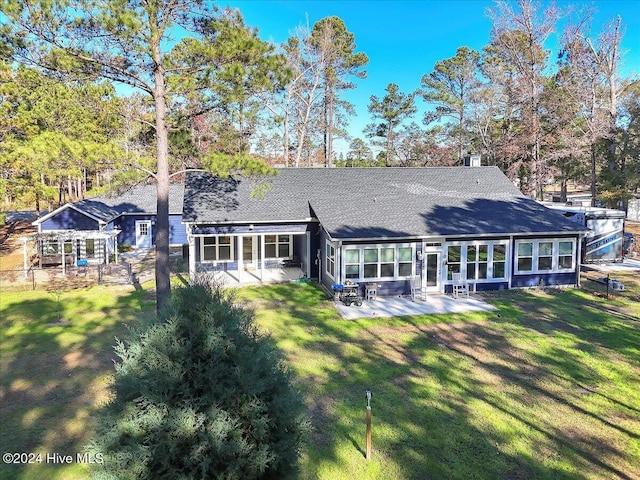 rear view of house featuring a patio area and a yard