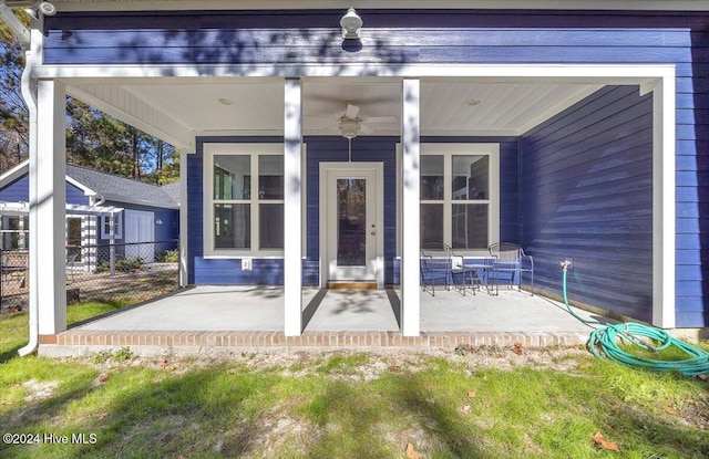 entrance to property with ceiling fan and a patio