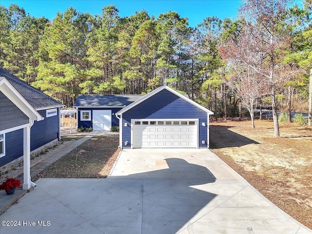 view of front of property with a garage and an outdoor structure