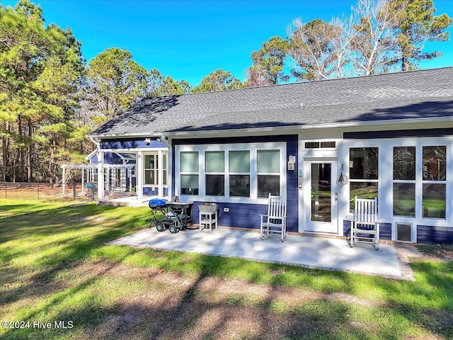 rear view of property featuring a patio and a yard