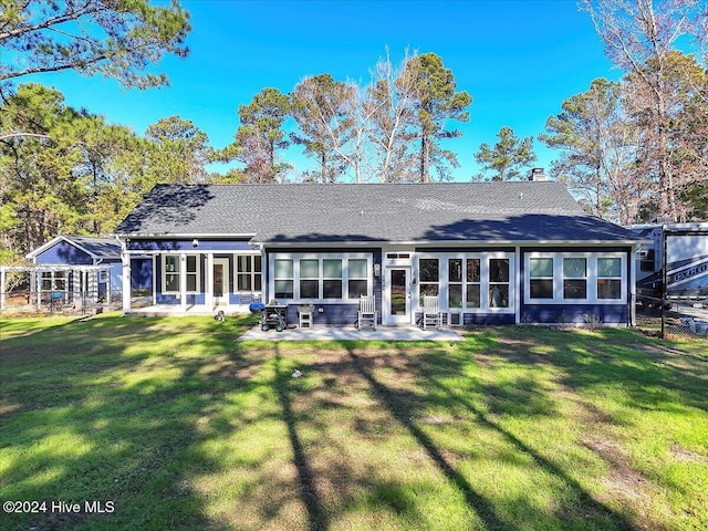 back of property featuring a lawn and a patio