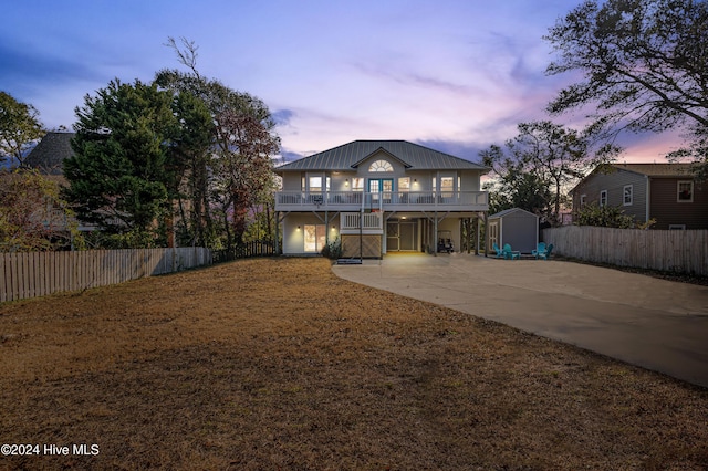 view of front of house featuring a balcony and a shed