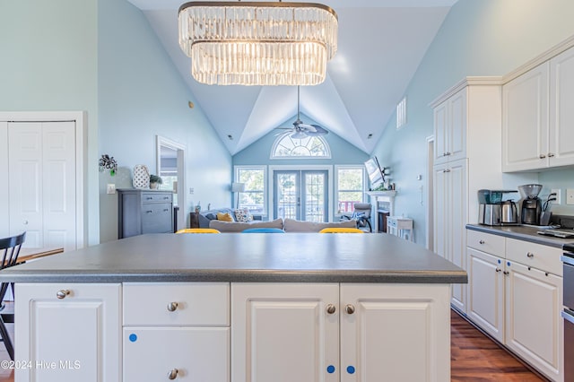 kitchen with white cabinets, a center island, and lofted ceiling