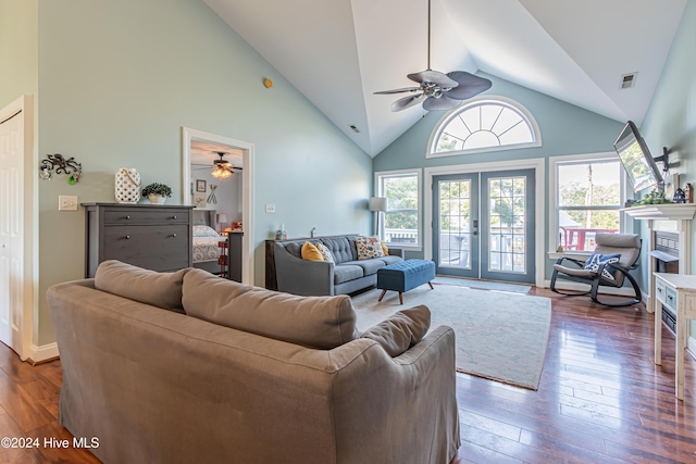 living room with ceiling fan, french doors, dark wood-type flooring, high vaulted ceiling, and a fireplace