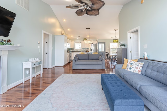 living room with ceiling fan, dark hardwood / wood-style flooring, high vaulted ceiling, and sink