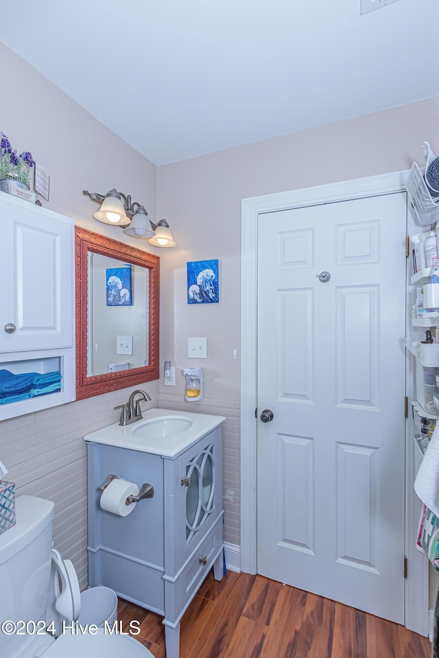 bathroom with vanity, hardwood / wood-style flooring, and toilet