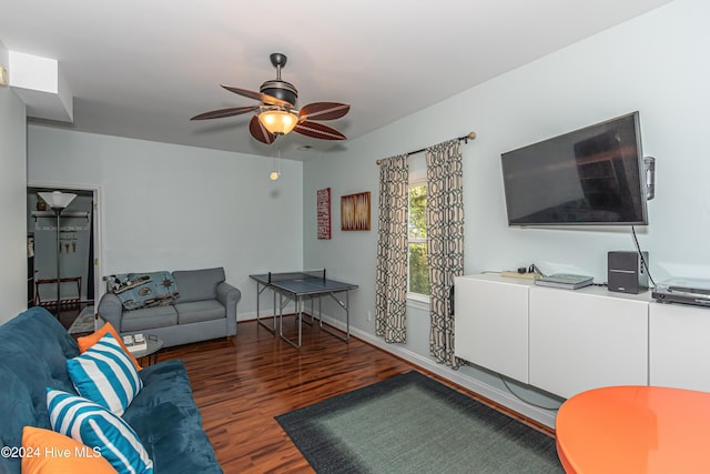 living room with ceiling fan and dark wood-type flooring