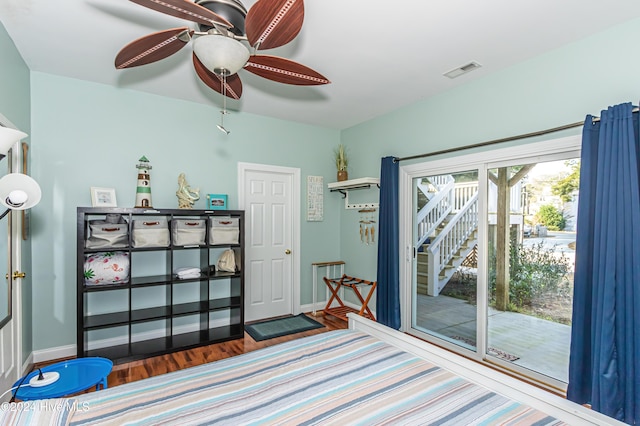 bedroom with access to exterior, hardwood / wood-style floors, multiple windows, and ceiling fan