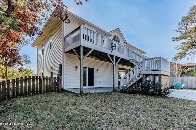 back of house with a patio, a deck, and a lawn