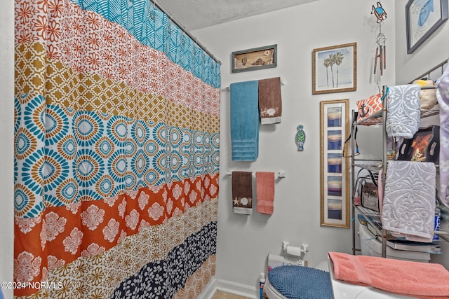 bathroom with a textured ceiling and toilet