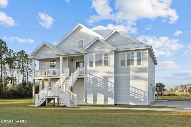 beach home featuring covered porch and a front yard