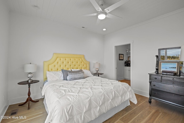 bedroom featuring connected bathroom, ceiling fan, and wood-type flooring