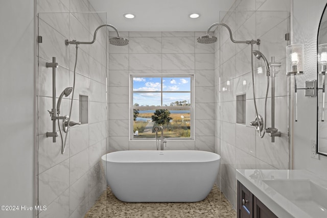 bathroom featuring shower with separate bathtub, vanity, and tile walls