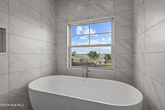 bathroom featuring a tub and tile walls