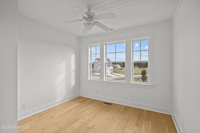 empty room with light hardwood / wood-style flooring, plenty of natural light, and ornamental molding