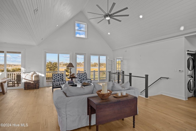 living room featuring ceiling fan, wooden ceiling, high vaulted ceiling, stacked washer / dryer, and light wood-type flooring