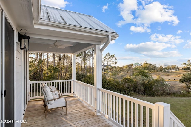 wooden deck featuring a lawn, ceiling fan, and covered porch