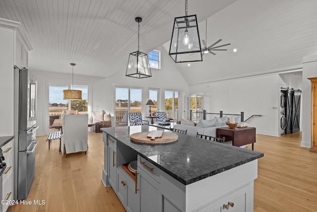 kitchen featuring white cabinetry, a center island, light hardwood / wood-style flooring, decorative light fixtures, and wood ceiling