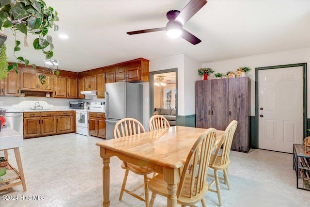 dining space featuring ceiling fan and sink