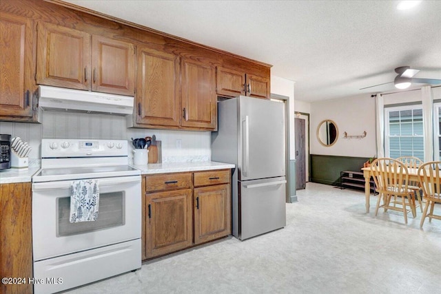 kitchen featuring stainless steel refrigerator, white range with electric cooktop, ceiling fan, and a textured ceiling