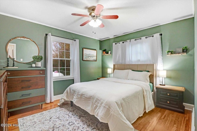 bedroom featuring ceiling fan, light hardwood / wood-style floors, and ornamental molding