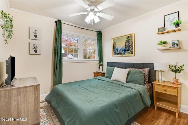 bedroom with hardwood / wood-style flooring, ceiling fan, and crown molding