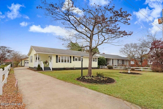 ranch-style house featuring a garage, an outbuilding, and a front yard