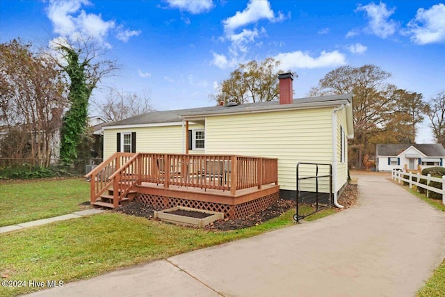 rear view of property with a yard and a deck