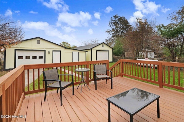 wooden deck featuring an outbuilding and a garage