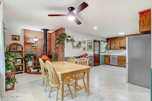 dining room with ceiling fan and a wood stove