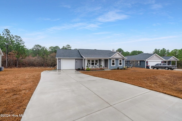 ranch-style home with a garage, covered porch, and cooling unit