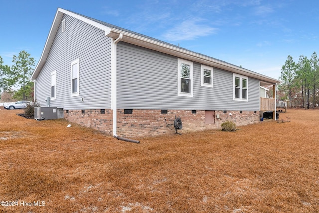 view of side of property featuring central AC and a lawn