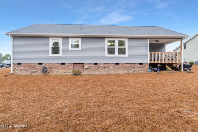 rear view of property with a lawn, ceiling fan, and a deck