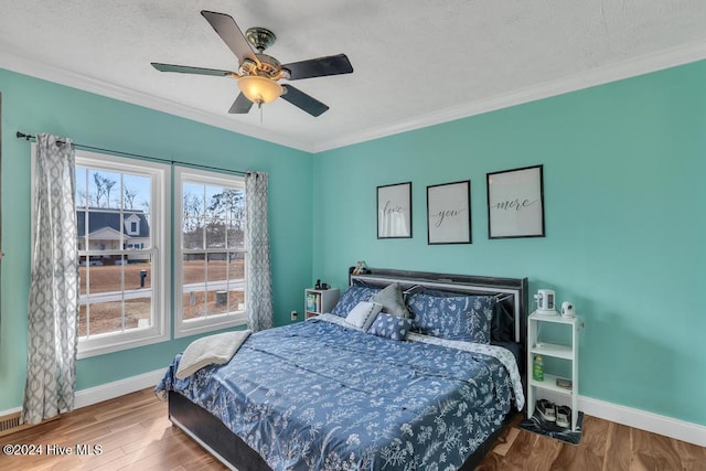 bedroom with hardwood / wood-style flooring, ceiling fan, and ornamental molding