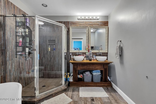 bathroom with hardwood / wood-style floors, vanity, and a shower with shower door